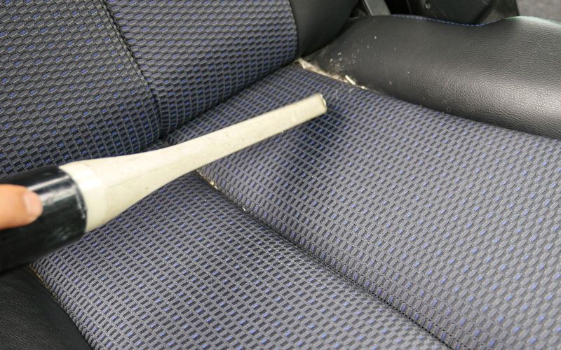 シートを掃除機で吸い取っている